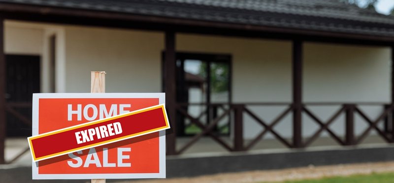 A red HOME FOR SALE sign in front of a house, stamped EXPIRED