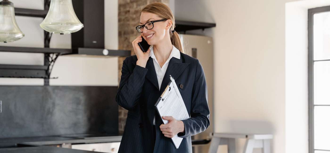 A real estate agent on the phone, notes in hand